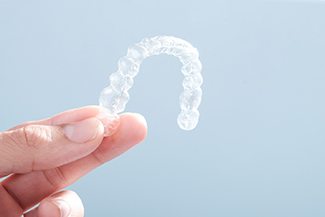 Patient holding Invisalign in Melbourne