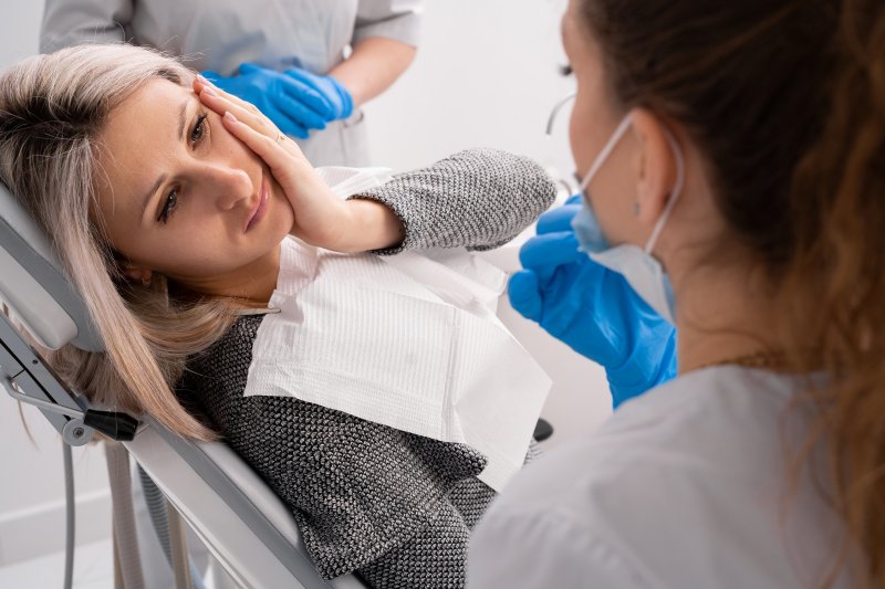 Lady in dentist's chair has oral discomfort